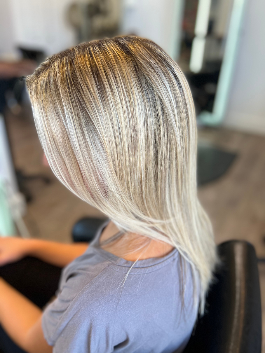 a person with blonde hair sitting in a salon chair. she had a lot of dimension throughout her hair done beautifully by strategically adding high and low lights in the right places